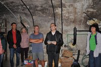 Gruppe von Personen in einem Kellerraum mit Gewölbedecke in Österreich.