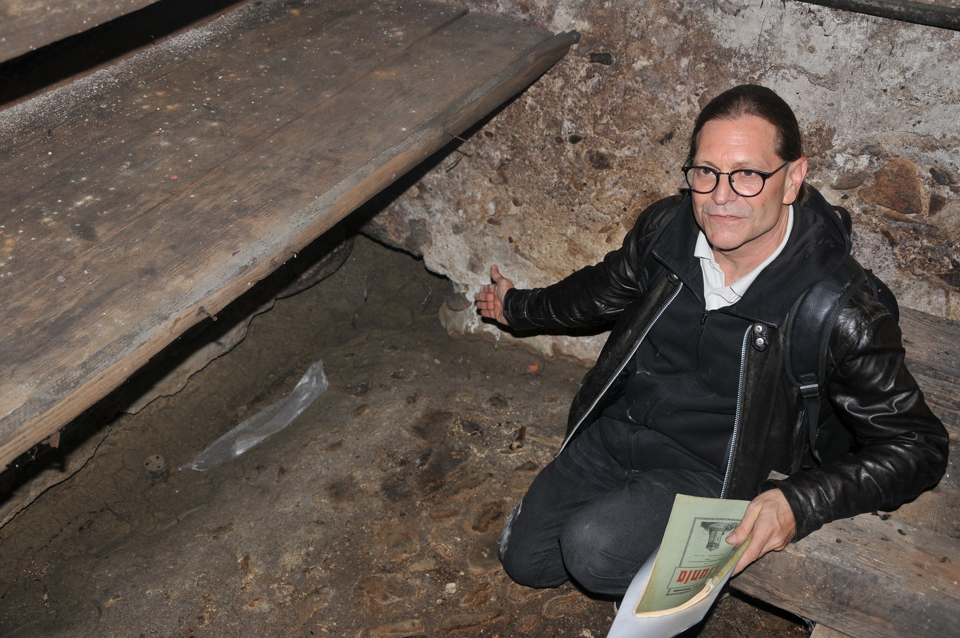 Archäologe Markus Brandstätter in einem Kellergewölbe in Wien mit historischen Dokumenten.